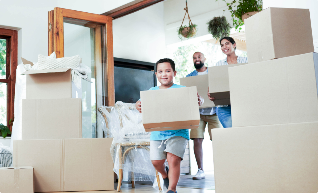 Family with moving boxes, thanks to a disaster relief home loan. They look happy and relieved.